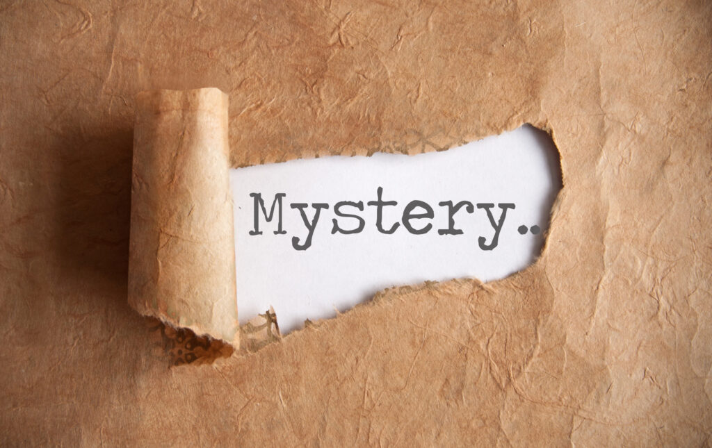 A brown paper wrapper torn to reveal the word mystery
